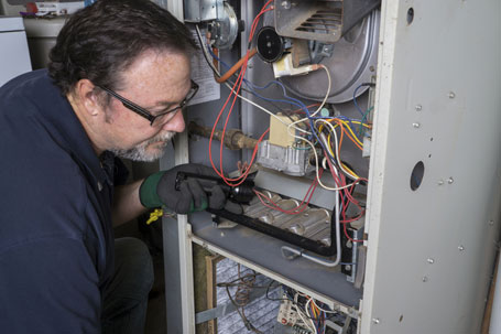 Technician Looking Over A Gas Furnace